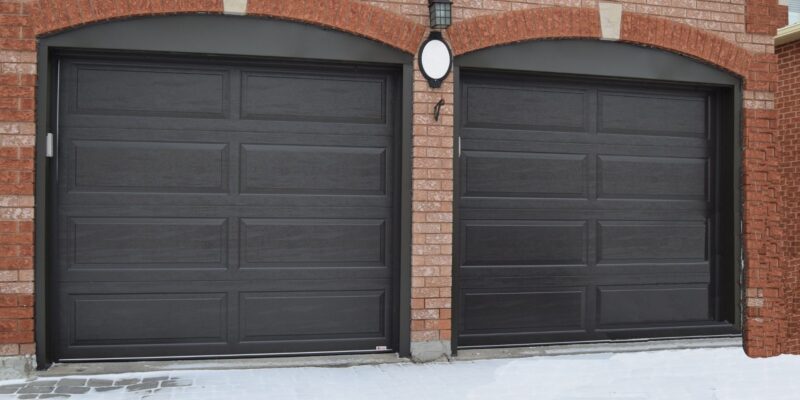 The Door Master- 2 black garage doors Raised Ranch Panel